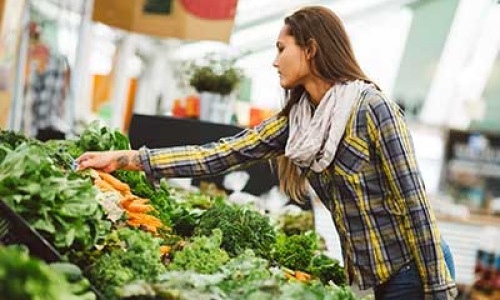 Lady at farmers market collecting vegetables